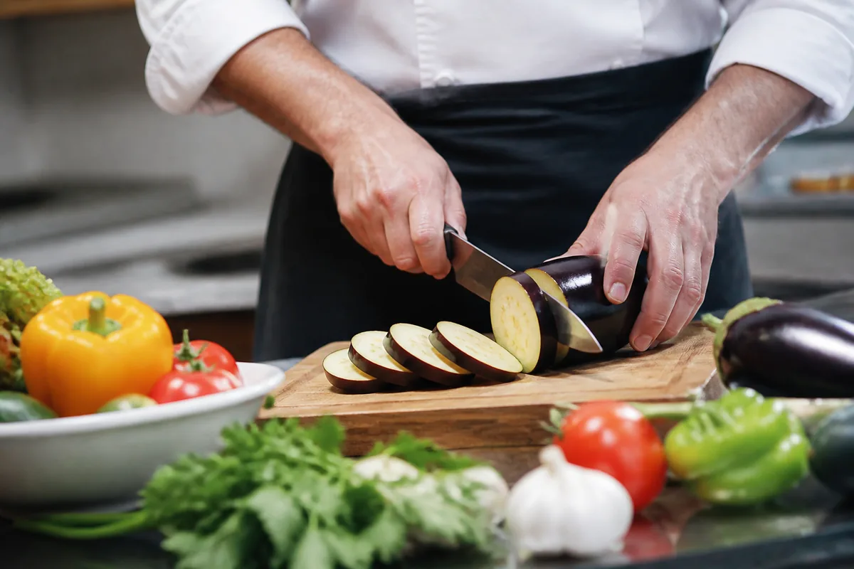 Plan rapproché de tranches d'aubergines fraîches préparées pour la cuisson dans une cuisine
